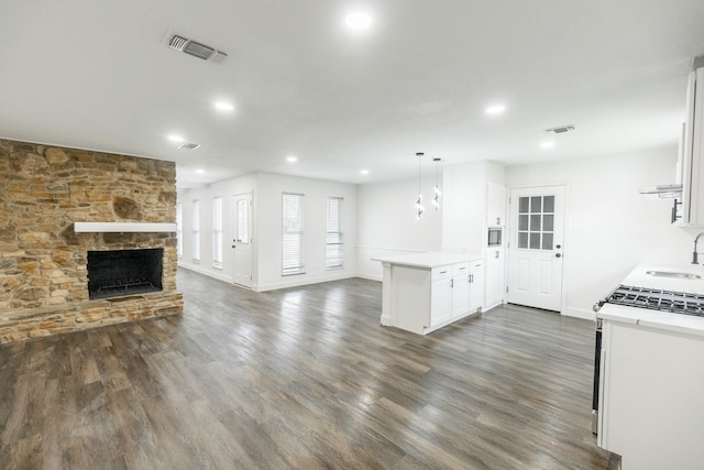 kitchen featuring gas range, open floor plan, visible vents, and dark wood-style floors