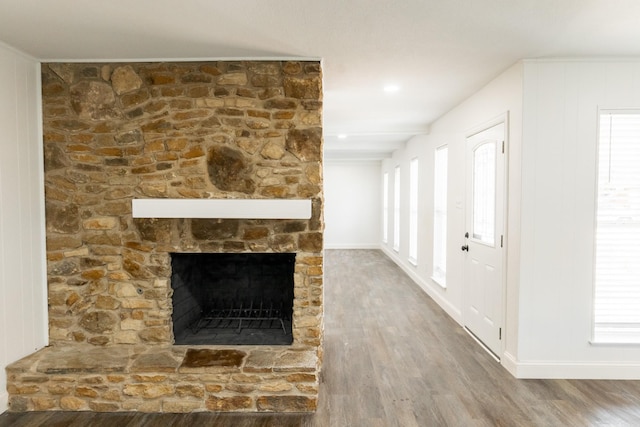 unfurnished living room featuring baseboards, a fireplace, and wood finished floors