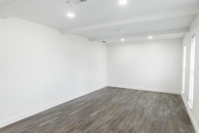 unfurnished room featuring beamed ceiling, visible vents, baseboards, and dark wood-style flooring