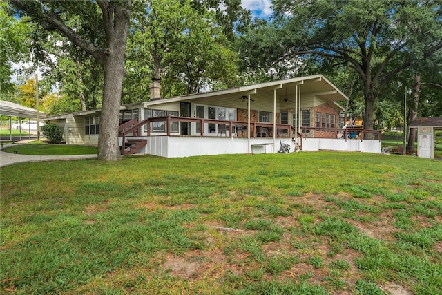 rear view of property featuring a chimney, a yard, and ceiling fan