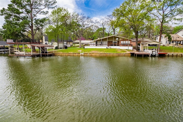 view of dock with a water view and a yard