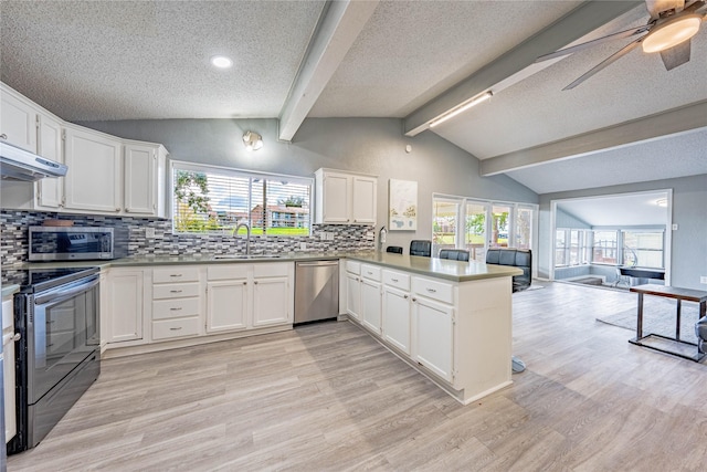 kitchen with vaulted ceiling with beams, a sink, light wood finished floors, a peninsula, and appliances with stainless steel finishes