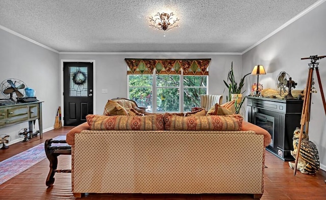 living room featuring a textured ceiling, ornamental molding, and wood finished floors