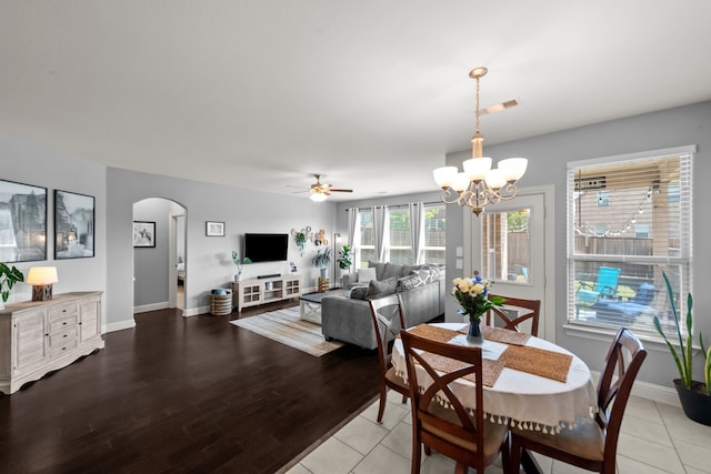 11317 Denet Creek Ln, Fort Worth, TX 76108 - dining room with arched walkways, visible vents, baseboards, light wood-style floors, and ceiling fan with notable chandelier
