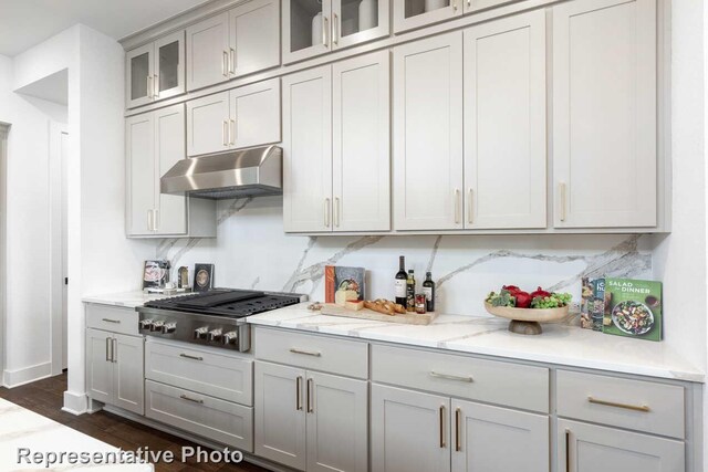 2352 Flora Dr, Mclendon Chisholm, TX 75032 - kitchen with under cabinet range hood, stainless steel gas stovetop, gray cabinets, glass insert cabinets, and light stone counters