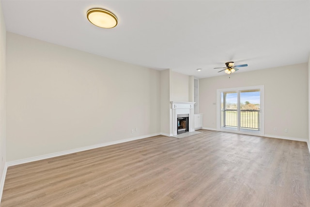 8511 Westover Ct Unit 217, Granbury, TX 76049 - unfurnished living room featuring a ceiling fan, light wood-style flooring, a fireplace, and baseboards