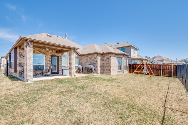 3721 Homeplace Dr, Celina, TX 75009 - back of property featuring brick siding, a patio area, a fenced backyard, and a playground
