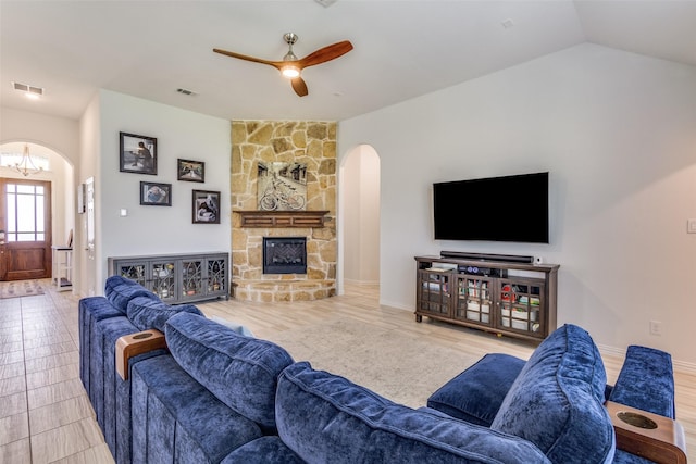 3721 Homeplace Dr, Celina, TX 75009 - living area with arched walkways, a ceiling fan, a stone fireplace, a chandelier, and vaulted ceiling