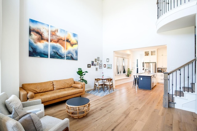 3640 Sevilla Dr, Frisco, TX 75034 - living room featuring a high ceiling, stairway, and light wood-type flooring