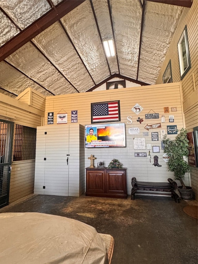 3163 Ranch Rd, Athens, TX 75751 - bedroom with concrete floors, wood walls, vaulted ceiling, and a garage