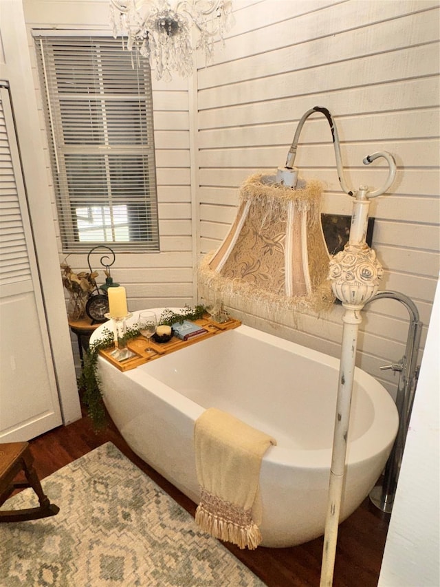 3163 Ranch Rd, Athens, TX 75751 - bathroom featuring a chandelier, wood finished floors, a tub, and wood walls