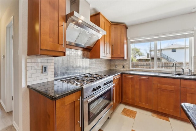 kitchen featuring stainless steel stove, wall chimney exhaust hood, and brown cabinets