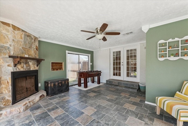 view of patio / terrace with french doors, a ceiling fan, and a stone fireplace