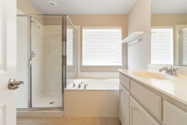 bathroom with a stall shower, a garden tub, vanity, and tile patterned flooring