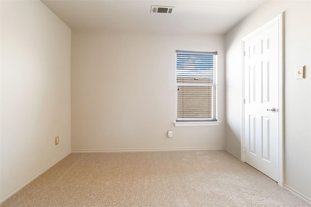 empty room featuring light carpet, baseboards, and visible vents