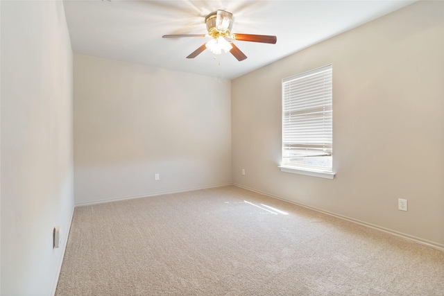 unfurnished room featuring carpet, baseboards, and a ceiling fan
