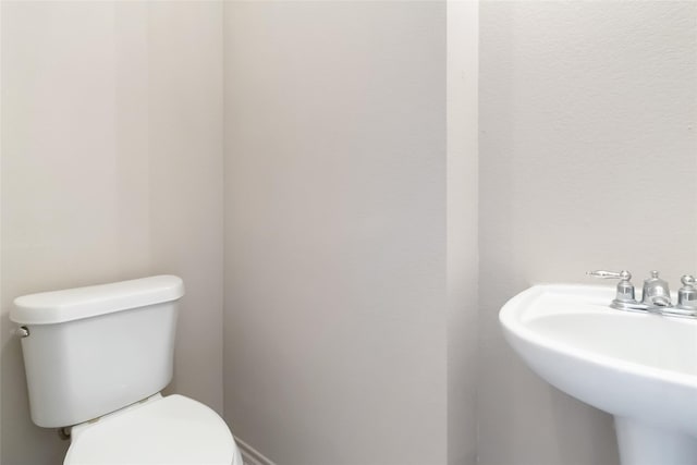 half bathroom with toilet and a sink