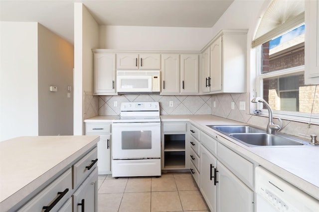 kitchen with light tile patterned floors, white appliances, light countertops, a sink, and decorative backsplash