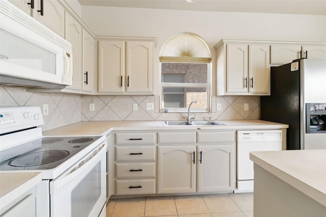 kitchen featuring a sink, light countertops, white appliances, and light tile patterned flooring