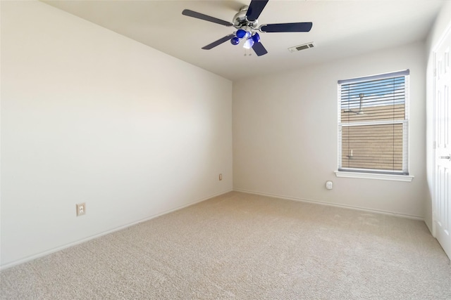 carpeted spare room featuring ceiling fan, baseboards, and visible vents