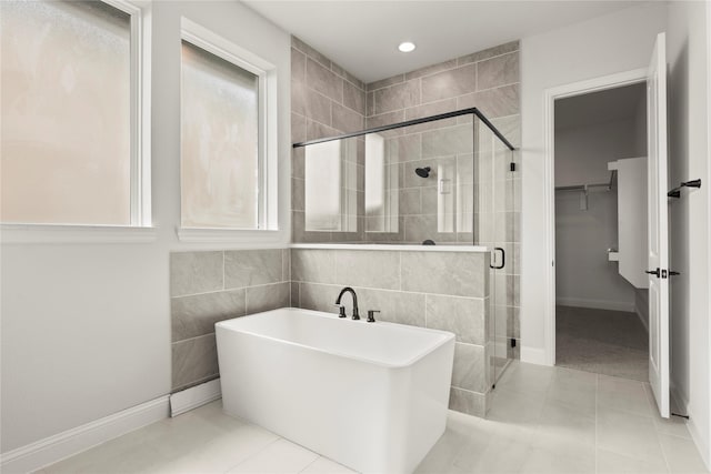 2109 Stratford Rd, Rockwall, TX 75087 - bathroom featuring a freestanding bath, a stall shower, a walk in closet, baseboards, and tile patterned floors