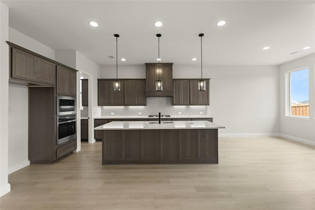 2109 Stratford Rd, Rockwall, TX 75087 - kitchen with oven, dark brown cabinets, light countertops, tasteful backsplash, and light wood-style flooring