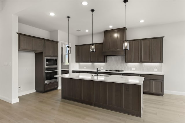 2109 Stratford Rd, Rockwall, TX 75087 - kitchen featuring stainless steel appliances, a sink, dark brown cabinetry, custom range hood, and decorative backsplash