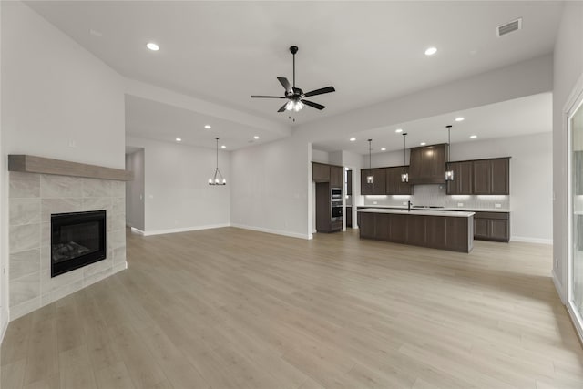 2109 Stratford Rd, Rockwall, TX 75087 - unfurnished living room with ceiling fan, a tiled fireplace, light wood finished floors, recessed lighting, and baseboards
