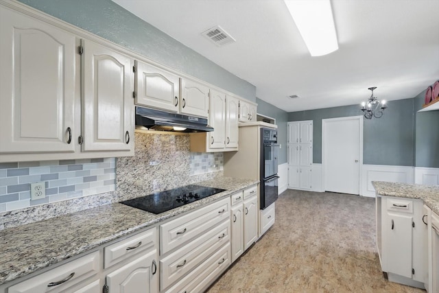 kitchen featuring under cabinet range hood, black appliances, a chandelier, and tasteful backsplash