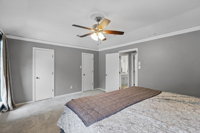 carpeted bedroom with ornamental molding, baseboards, multiple closets, and ceiling fan