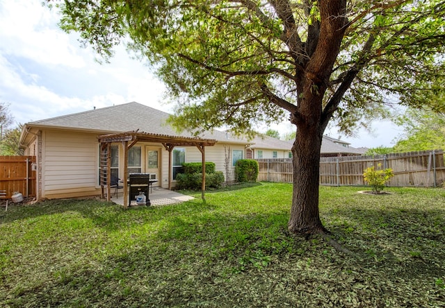 rear view of property with a lawn, a fenced backyard, a pergola, and a patio area