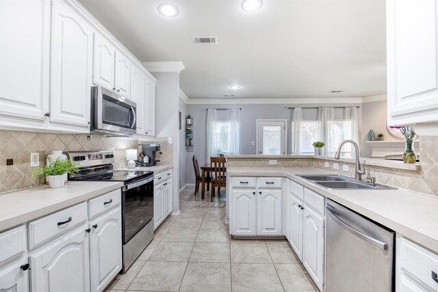 kitchen with crown molding, a sink, appliances with stainless steel finishes, visible vents, and white cabinets