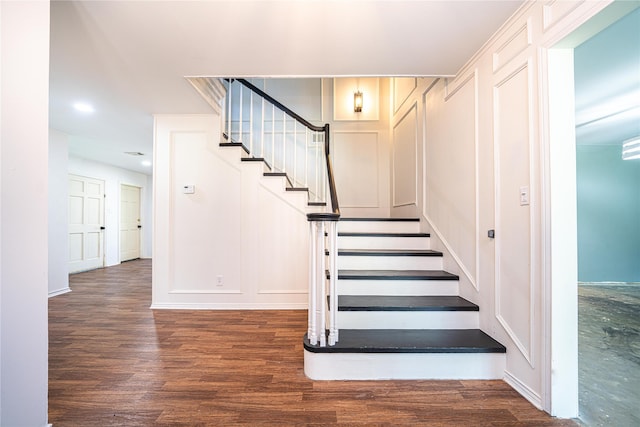 stairs featuring wood finished floors