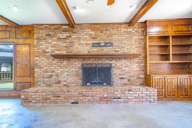 unfurnished living room featuring unfinished concrete flooring, a textured ceiling, beamed ceiling, and a wealth of natural light