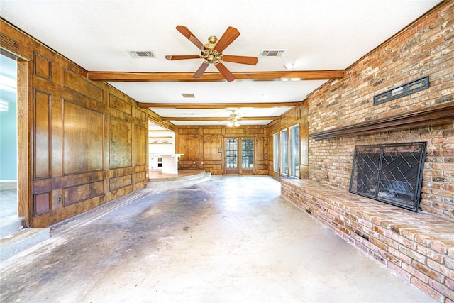 unfurnished living room with a brick fireplace, visible vents, a textured ceiling, and a ceiling fan