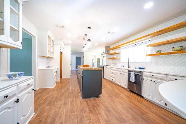 kitchen with a center island, white cabinetry, open shelves, light wood-style floors, and stainless steel dishwasher