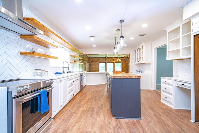 kitchen with range hood, open shelves, stainless steel range with electric cooktop, butcher block counters, and white cabinets