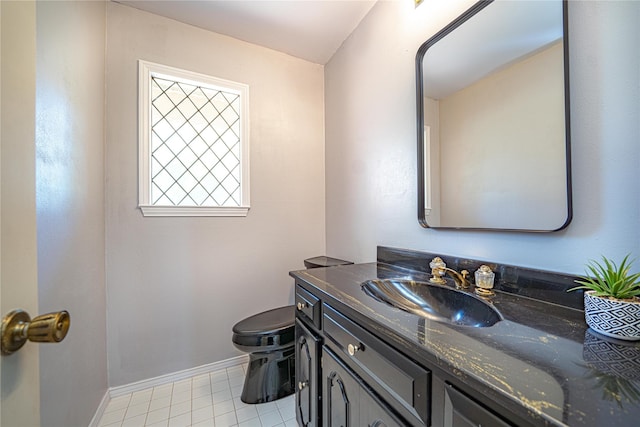 half bath featuring baseboards, toilet, tile patterned flooring, and vanity