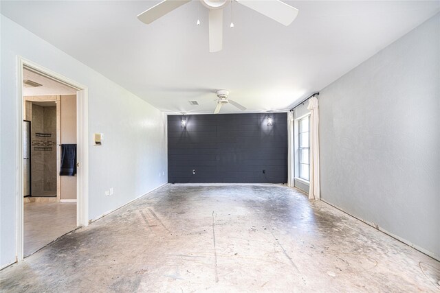 empty room with unfinished concrete flooring and a ceiling fan