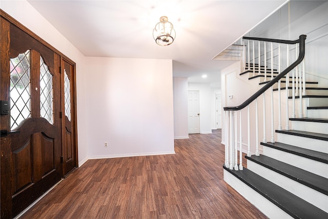 foyer entrance featuring stairs, wood finished floors, baseboards, and an inviting chandelier