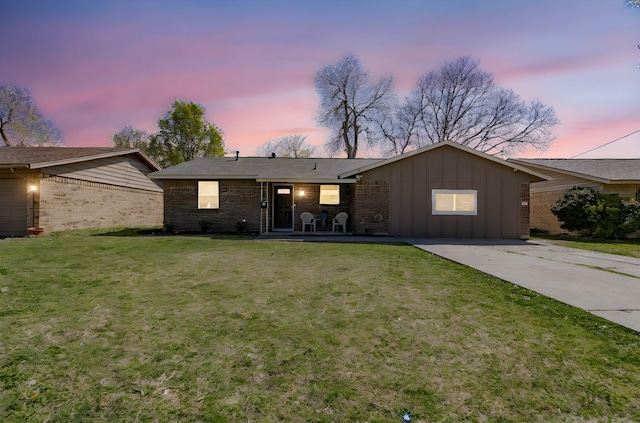 329 W Ferndale Ln, Grand Prairie, TX 75052 - view of front facade featuring brick siding, driveway, a front yard, and board and batten siding