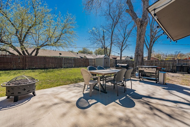 329 W Ferndale Ln, Grand Prairie, TX 75052 - view of patio with outdoor dining area, a fenced backyard, a storage unit, an outbuilding, and a fire pit