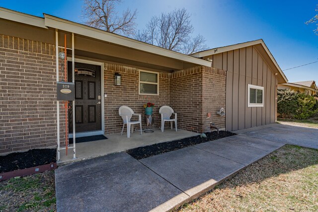 329 W Ferndale Ln, Grand Prairie, TX 75052 - entrance to property featuring brick siding, board and batten siding, and a porch