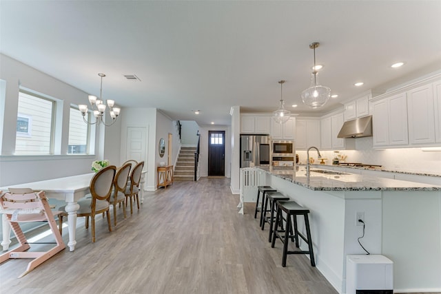 kitchen featuring under cabinet range hood, appliances with stainless steel finishes, baseboards, light wood-type flooring, and recessed lighting