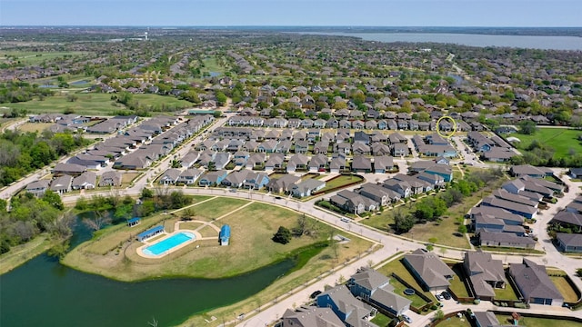aerial overview of property's location with a nearby body of water, nearby suburban area, and a pool