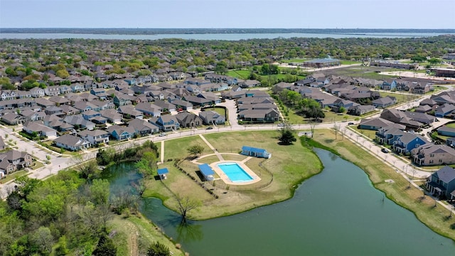 aerial view of property's location featuring a nearby body of water, nearby suburban area, and a pool