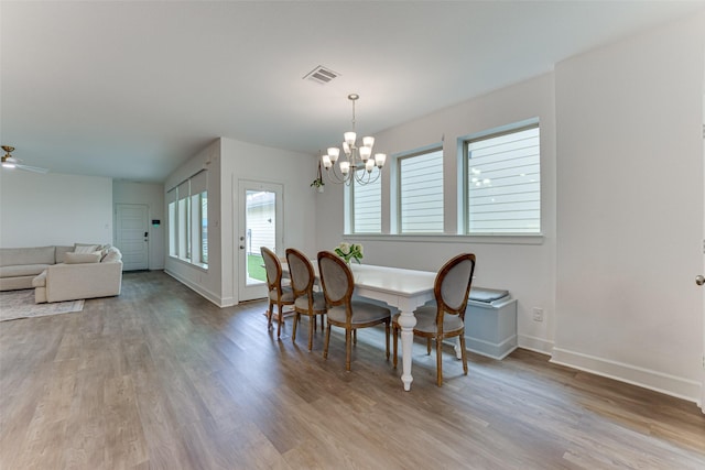dining area with wood finished floors, baseboards, a chandelier, and ceiling fan