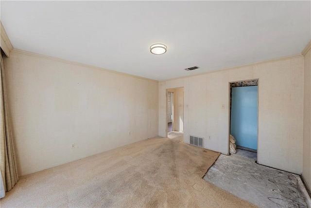 carpeted empty room featuring visible vents and ornamental molding