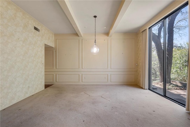 empty room featuring a decorative wall, light carpet, beam ceiling, and visible vents