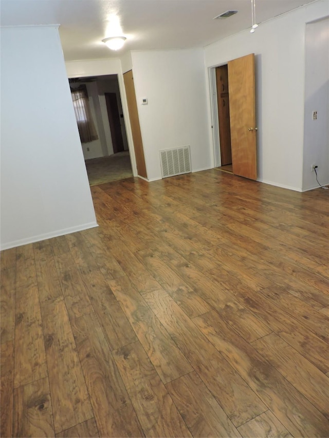 empty room featuring wood-type flooring and visible vents